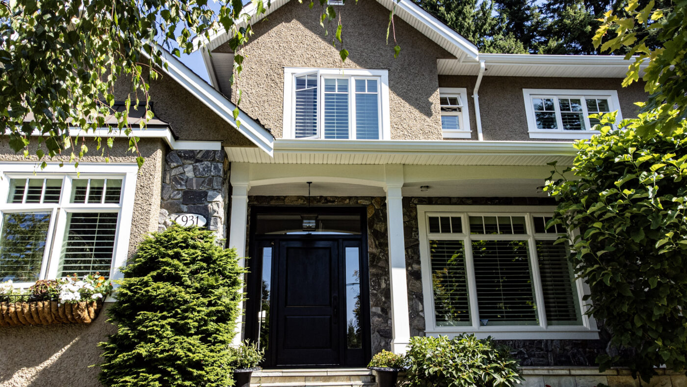 A shot of a single house from the front. There are trees in the garden. This is one of the examples of exterior paintings of Armstrong Custom Decorating